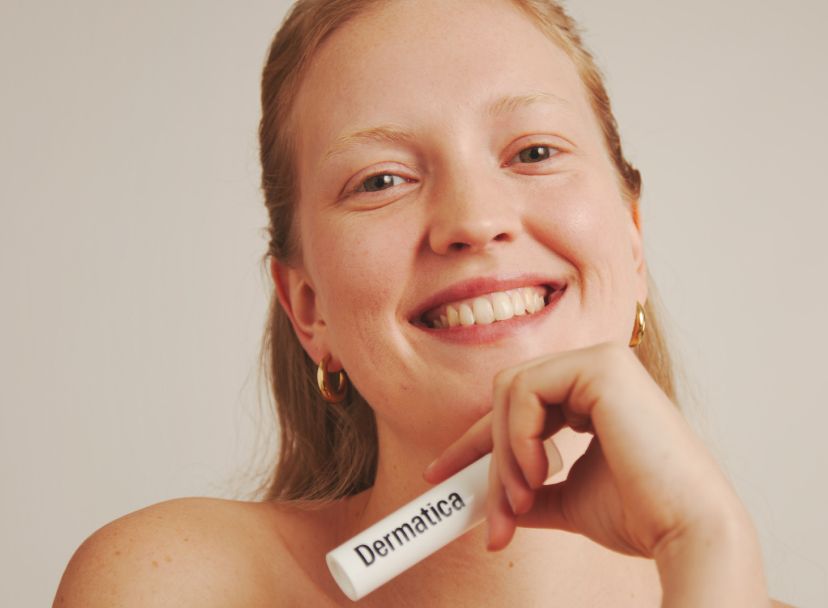Dermatica - Smiling woman holding Dermatica bottle in the hand