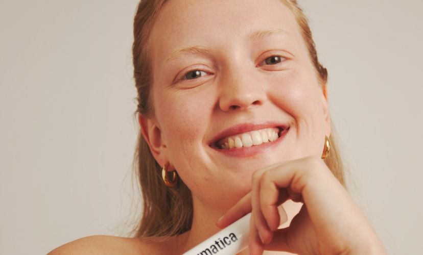 Dermatica - Smiling woman holding Dermatica bottle in the hand
