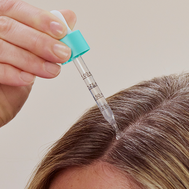Person applying hair loss serum